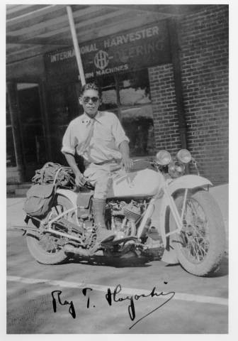 Roy T. Hayoshi on motorcycle in front of International Harvester store