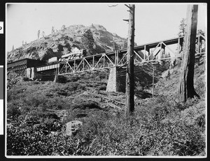 Southern Pacific "Cab Forward" steam locomotive coming out of Snow Shed 10, heading West onto Butte Canyon Trestle, ca.1910