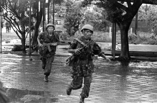 Soldiers run in the street, Nicaragua, 1979