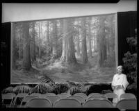 Martella Lane poses with painting of California Redwoods