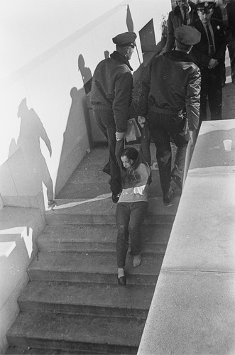 Sue Trupin being carried up steps to bus after being arrested in Sproul Hall