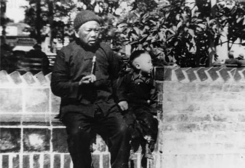 Quon Soong Hoo (the elderly man), sitting with Ernest Young (Howard's brother) on a brick seat