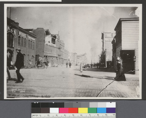 [Street scene of earthquake-damaged structures and fire in distance.]