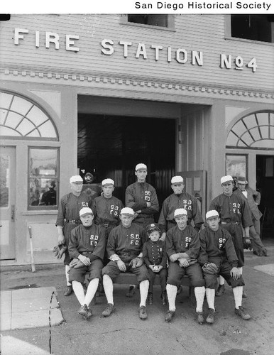 San Diego Fire Station No. 4 baseball team and child mascot outside the station