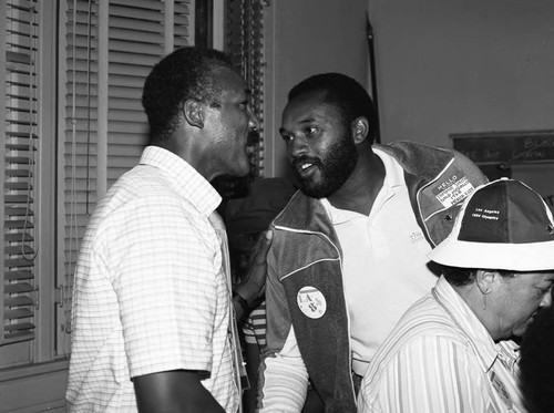 Tommie Smith and John Carlos talking together at a neighborhood event, Los Angeles, 1984