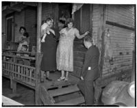 Poverty-stricken family speaks to unidentified man outside of their dilapidated home, Los Angeles, 1930s