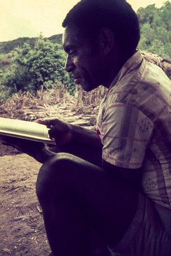 Missionary's trainee reading the New Testament in Pidgin English (Tok Pisin)