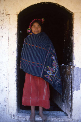 Mayan woman stands barefoot in the doorway, Chajul, 1982