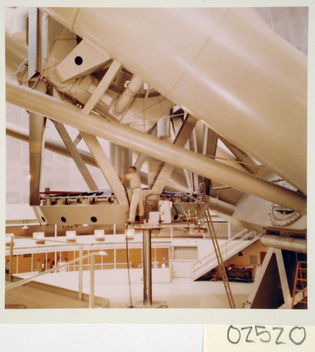Workman performing maintenance on the 200-inch telescope, Palomar Observatory