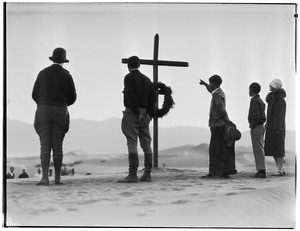 Six people standing around a cross at a funeral