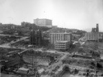 [View of Nob Hill up Stockton St. during reconstruction. Temple Emanu-el in scaffolding on Sutter St., center; Fairmont Hotel atop hill; Grace Church, right]