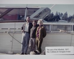 Hal, Cathleen, and Georgina Evans stand by the boat "Mindick" in Marshall, Marin County, California, December 1967