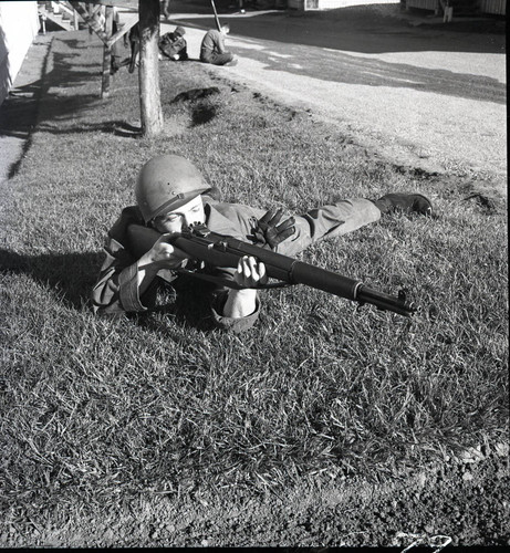 Trainee posing with rifle in prone position at Fort Ord