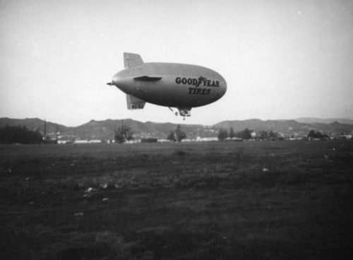 Goodyear blimp landing in a field