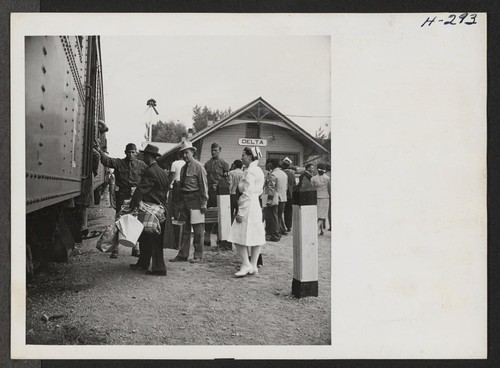 A scene at the little railway station of Delta, Utah, as transferees from the Topaz Center entrain for Tule Lake. One of the center's nurses is shown in attendance. Photographer: Mace, Charles E. Topaz, Utah