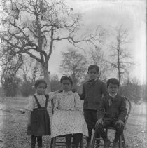 Exterior view of four children in a wooded area
