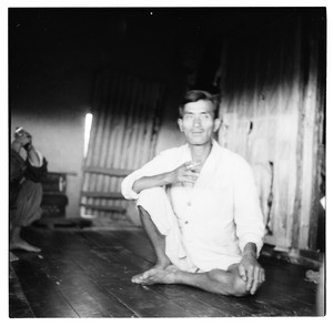 Man dressed in white, sitting on floor smoking a cigarett, South Korea