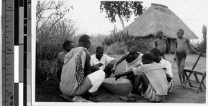 Group of men playing a game on a stone, Africa, April 1947