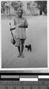 Man holding the leg of an antelope, Africa, October 1947