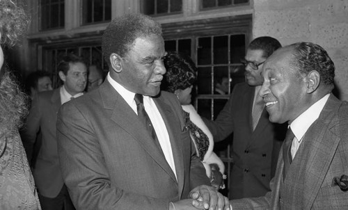 Mayor Harold Washington talking with an unidentified man at an event, Los Angeles, 1983