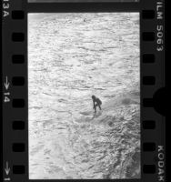 Lone surfer in whitewash of waves on Manhattan Beach, Calif., 1977