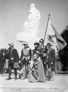Re-enactors standing in front of a statue of Juan Rodriquez Cabrillo on Cabrillo Beach in San Pedro