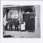 Men pose in front of Olander's bar at East 12th Street and 13th Avenue in Brooklyn Township, California