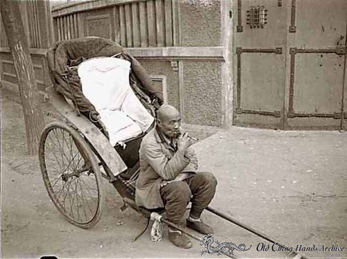 A rickshaw driver waiting for a customer on a street in Tientsin, spring 1946