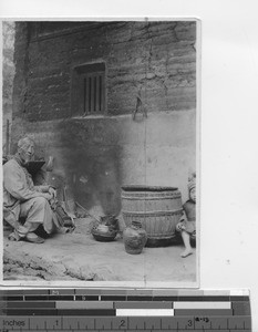 A Hakka man at his fire place at Meixien, China