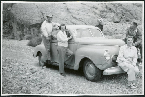 Photograph of the Merritt family surrounding a car in Titus Canyon in Death Valley