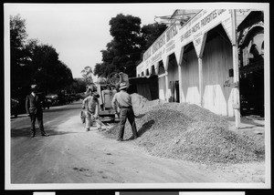 Department of Public Works employees shoveling gravel in the street near Piccadilly Apatment Hotel