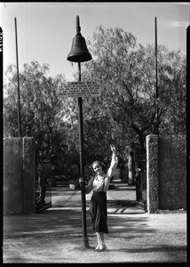 Club mission bell at Fremont-Pico memorial on Lankershim Blvd. with movie actress, North Hollywood, 1932