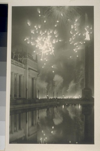 H285. [Fireworks display. Court of the Universe. Column of Progress, right, with "The Adventurous Bowman" illuminated atop.]