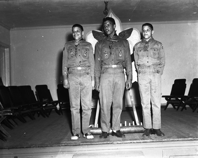 Three boy scouts standing on stage