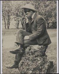 Jack London sitting on a tree stump at his Beauty Ranch, Glen Ellen, California, between 1910 and 1915