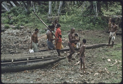 Fishing: men carry strings of fish that they have obtained from returned fishermen
