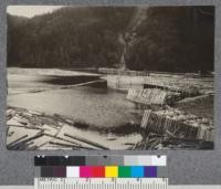 Piers for holding booms just above saw mill at mouth of Salmon River on property of Pejepscot Paper Company. The lower end of a "brow" described in following picture seen in background. D. T. Mason '19