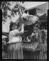 Lucy Gutierrez setting up her stand in preparation for the Founding Day Celebration on Olvera Street, Los Angeles, 1935