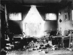 [Residential interior with hole in wall from collapsed fireplace and chimney. Unidentified location]
