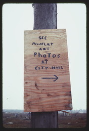 OCT78P9-12: "SEE MUDFLAT ART PHOTOS AT CITY HALL" sign