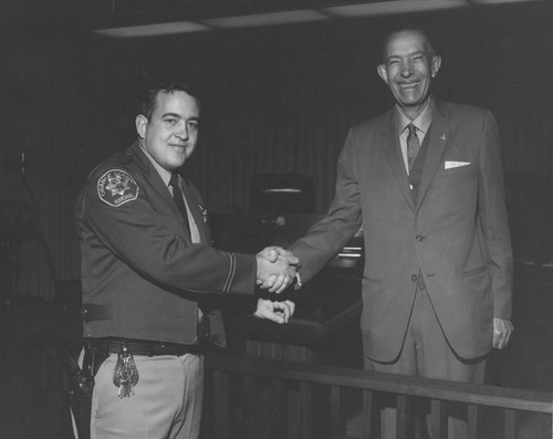 Orange County Supervisor C. M. Featherly shakes hands with an unidentified Orange County Marshal