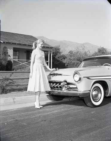 Mrs. America stands next to car