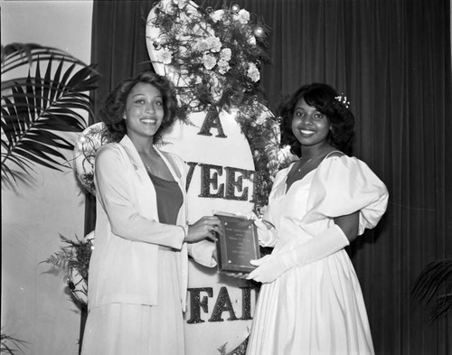 Theta Alpha Omega Chapter, AKA Sorority sister presenting an award to a debutante, Los Angeles, 1983