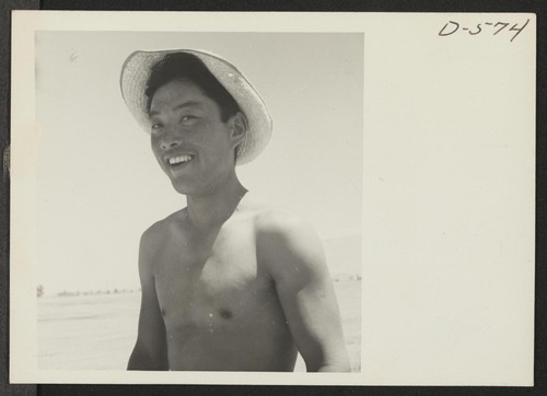 A young Nisei who assisted in sowing onions in the field at this relocation center. Photographer: Stewart, Francis Manzanar, California