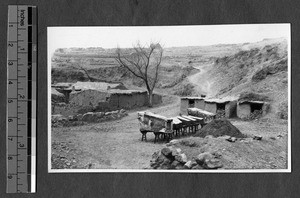 Coffins ready for burial in a mud village, China, ca.1920