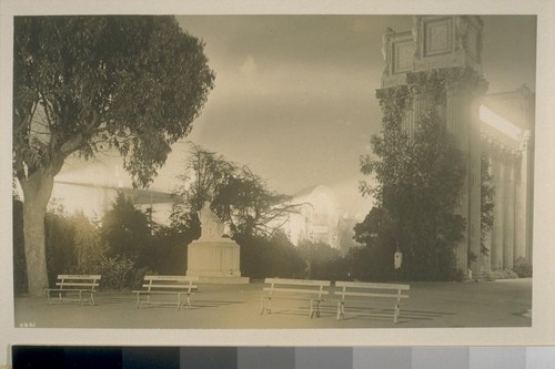 H261. [Exhibit garden, Palace of Fine Arts, illuminated. Statue of Chief Justice Marshall (Herbert Adams, sculptor), center; colonnade, Palace of Fine Arts, right; Palaces of Food Products and Education in distance.]