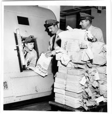 [Loomis Armored Car Service employees Frank Soto, John Leone and Nick Dentici loading money into a truck at the Federal Reserve Bank of San Francisco]
